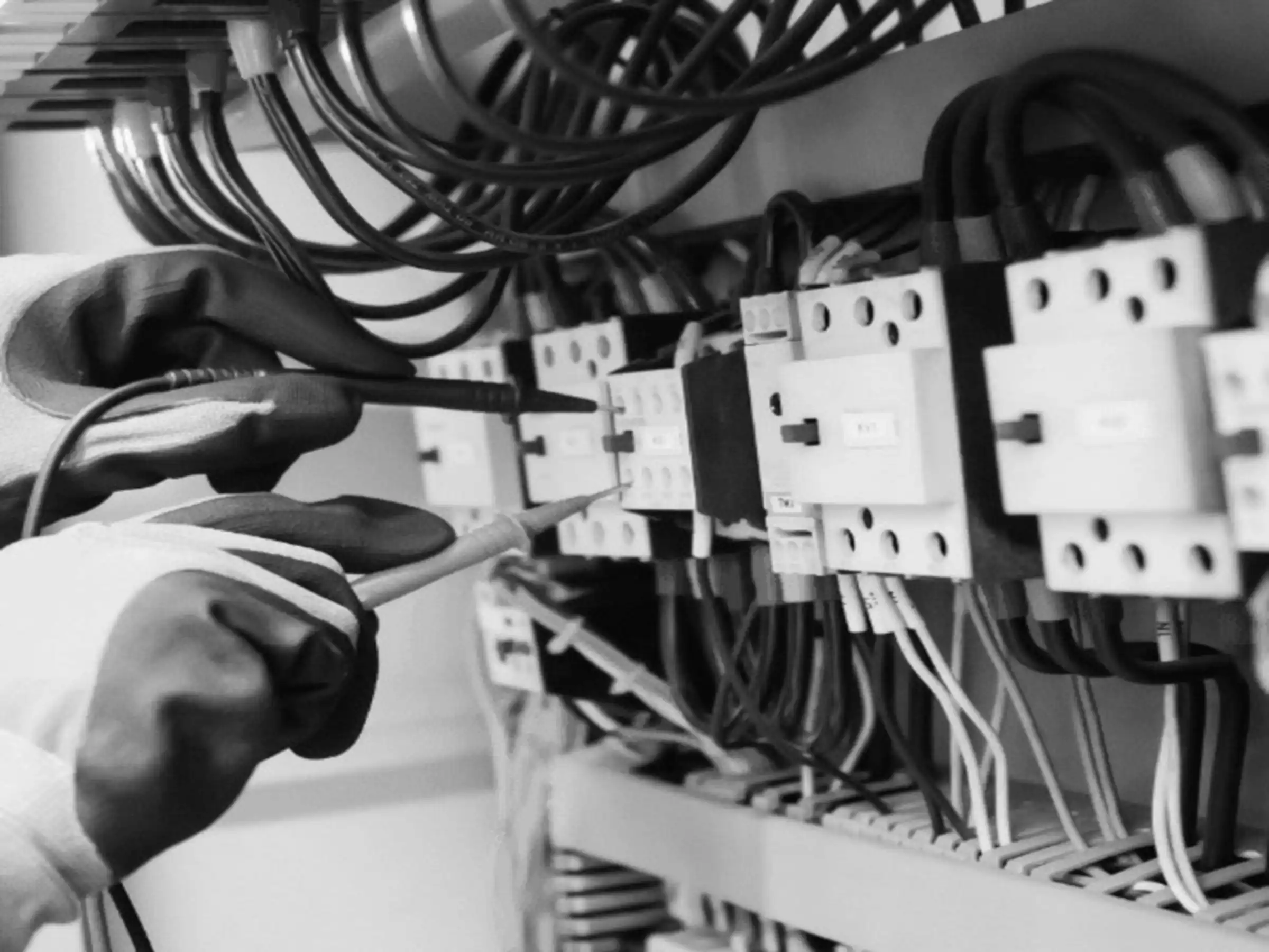 Técnico de mantenimiento midiendo con un multímetro en el cuadro eléctrico de un SAI